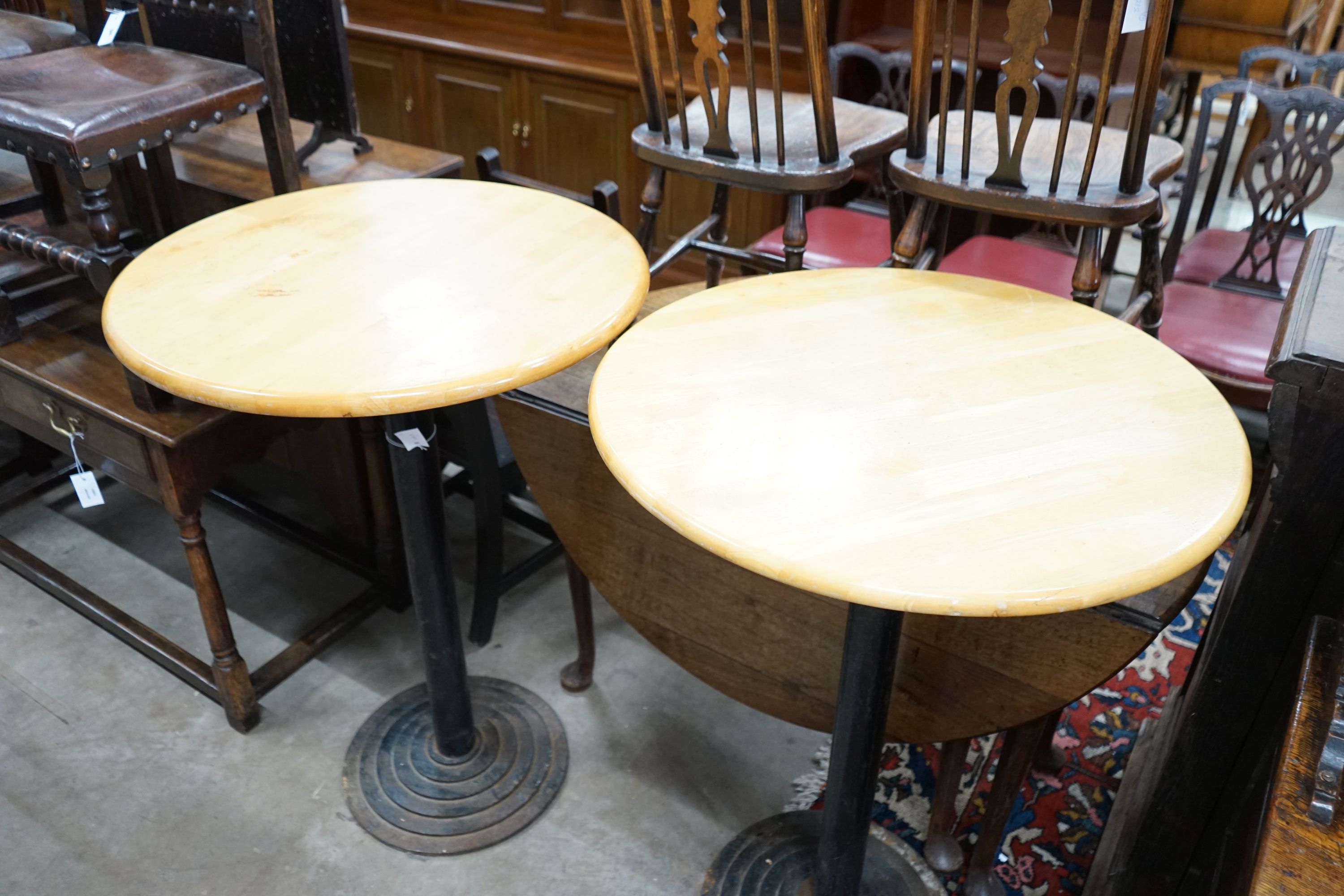 A pair of circular beech and iron pub tables, diameter 74cm, height 104cm